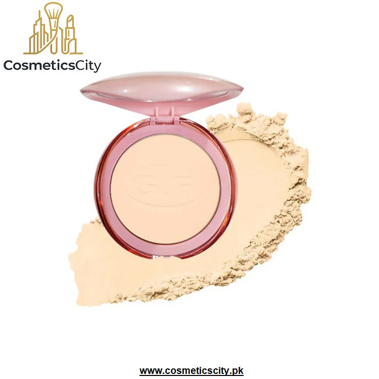 An open round compact of pressed powder foundation or bronzer with a translucent pink lid, shown with a smear of the light beige powder on a white background. The brand name 'CosmeticsCity' is visible in the top left corner.